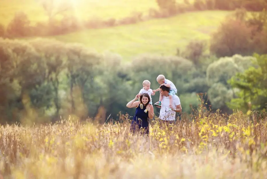 Family walking together through a sunlit summer meadow